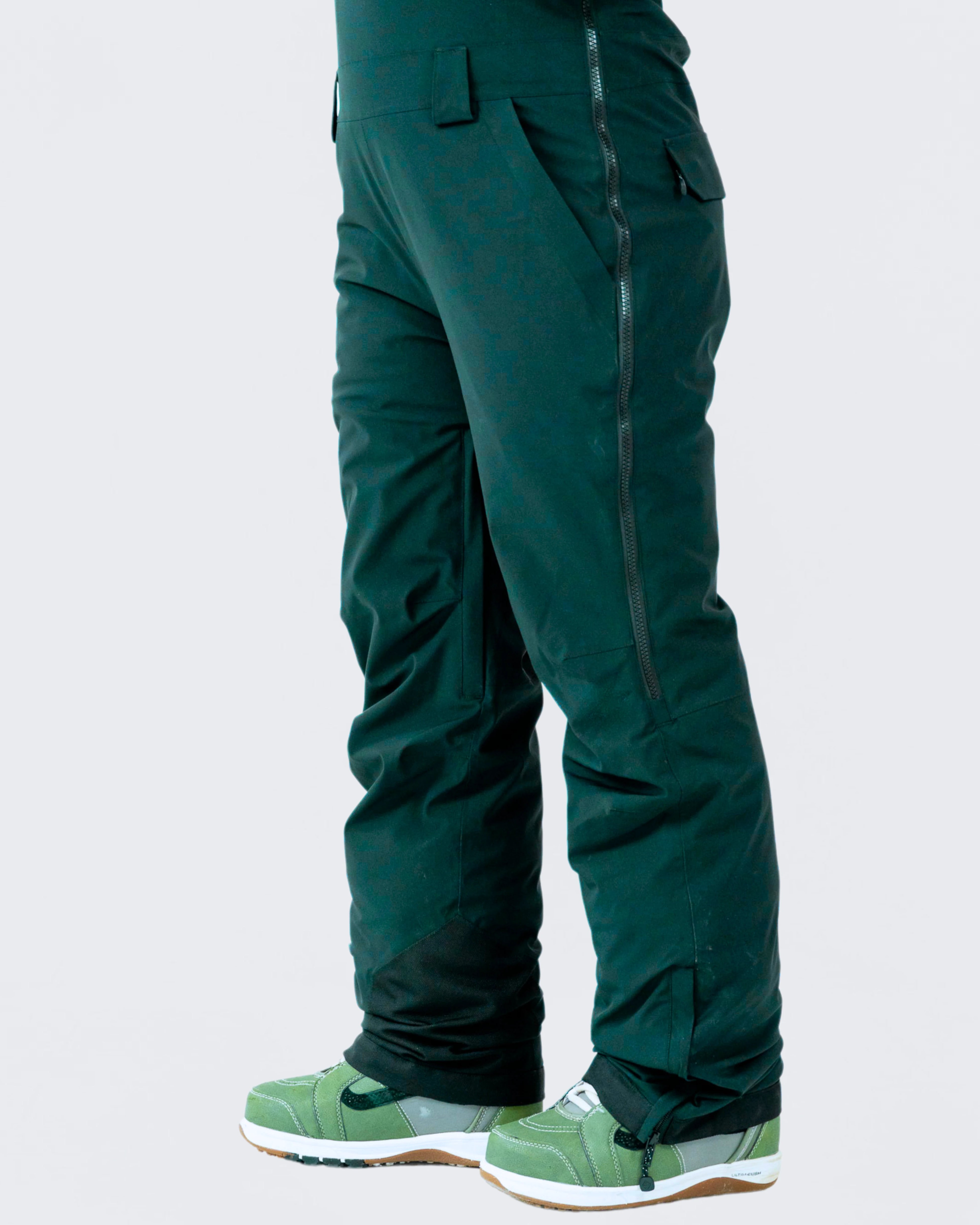 Side view of women's emerald green snow bib pants, designed for snowboarding and mountain adventures.