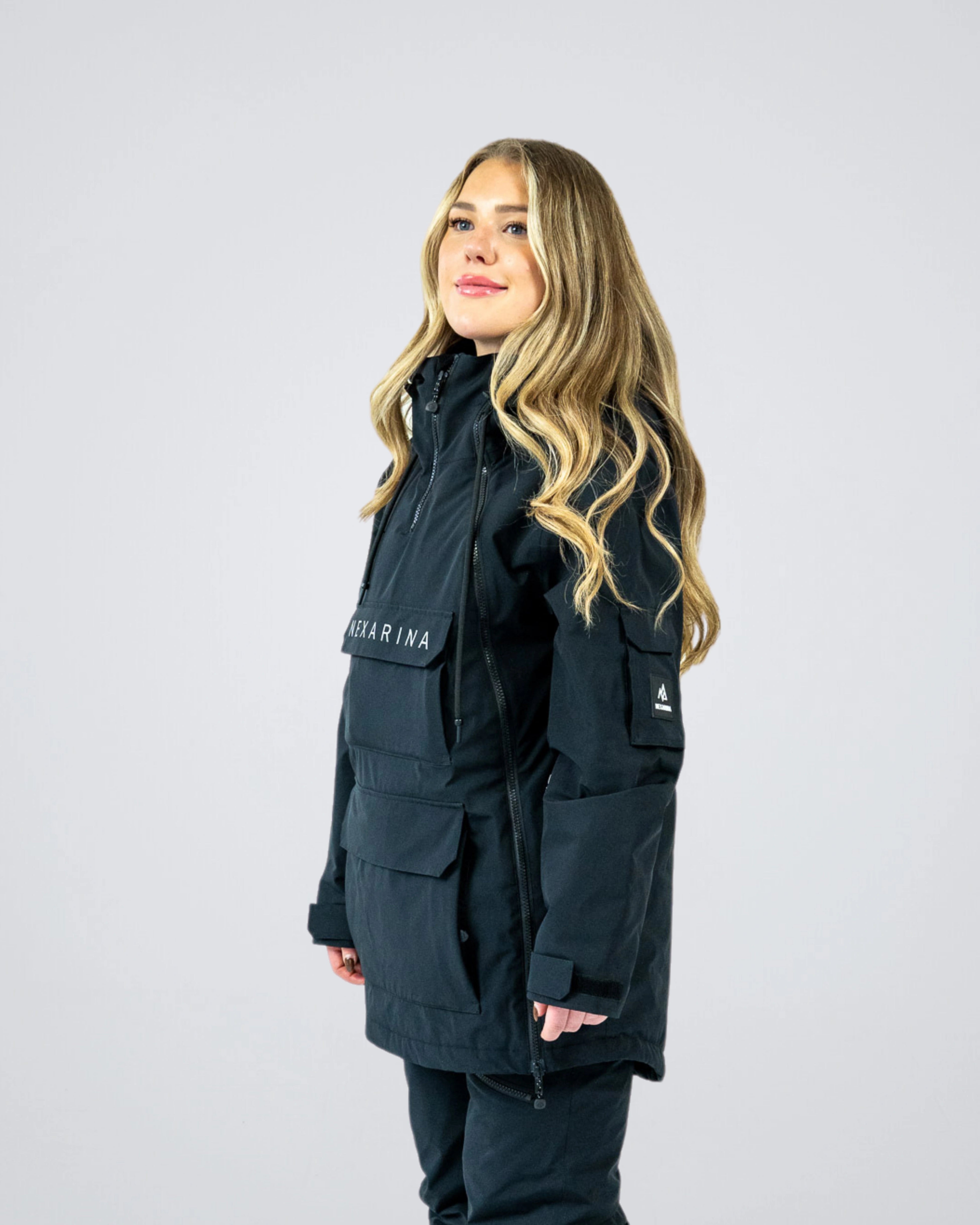 Woman wearing Nexarina Indy Snow Jacket in Classic Black, angled side view.