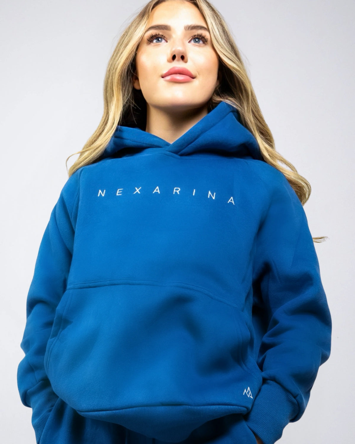 Front view of the Nexarina Everly Hoodie in Dusty Blue on a woman