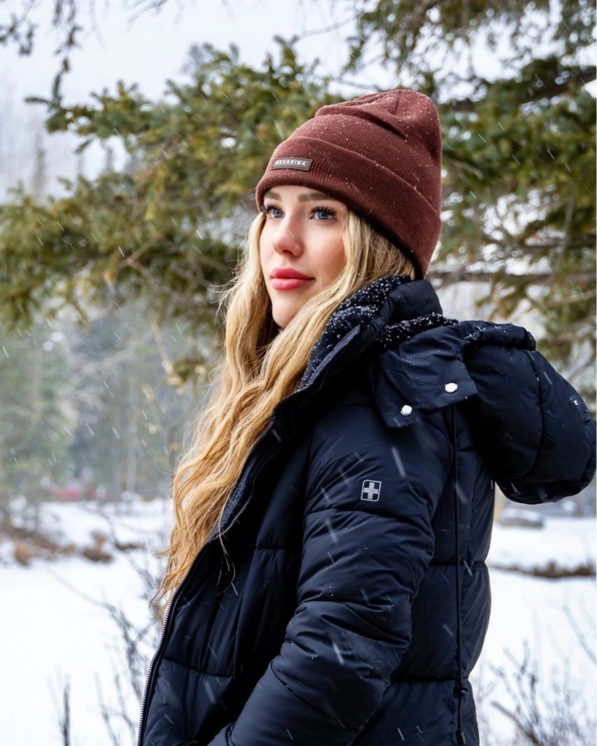 Woman wearing the Nexarina Coco brown beanie with a black winter jacket