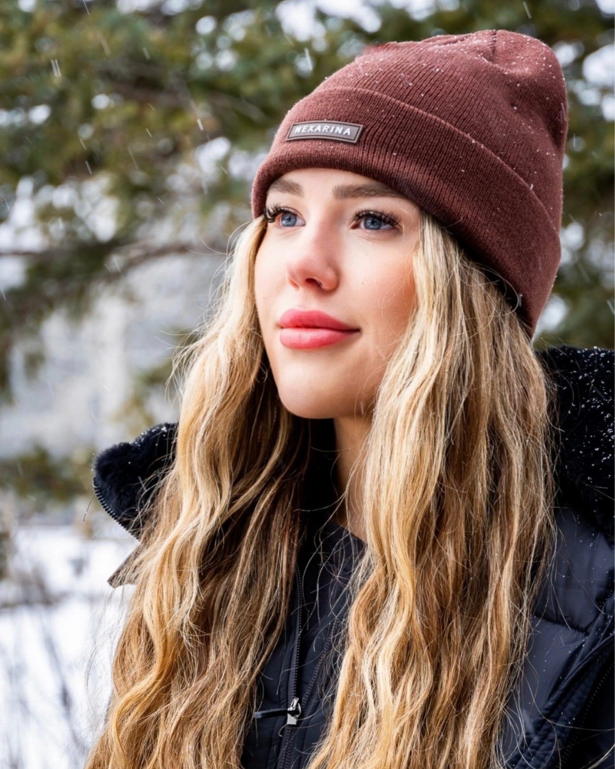 Woman wearing the Nexarina Coco brown knit beanie outdoors in winter