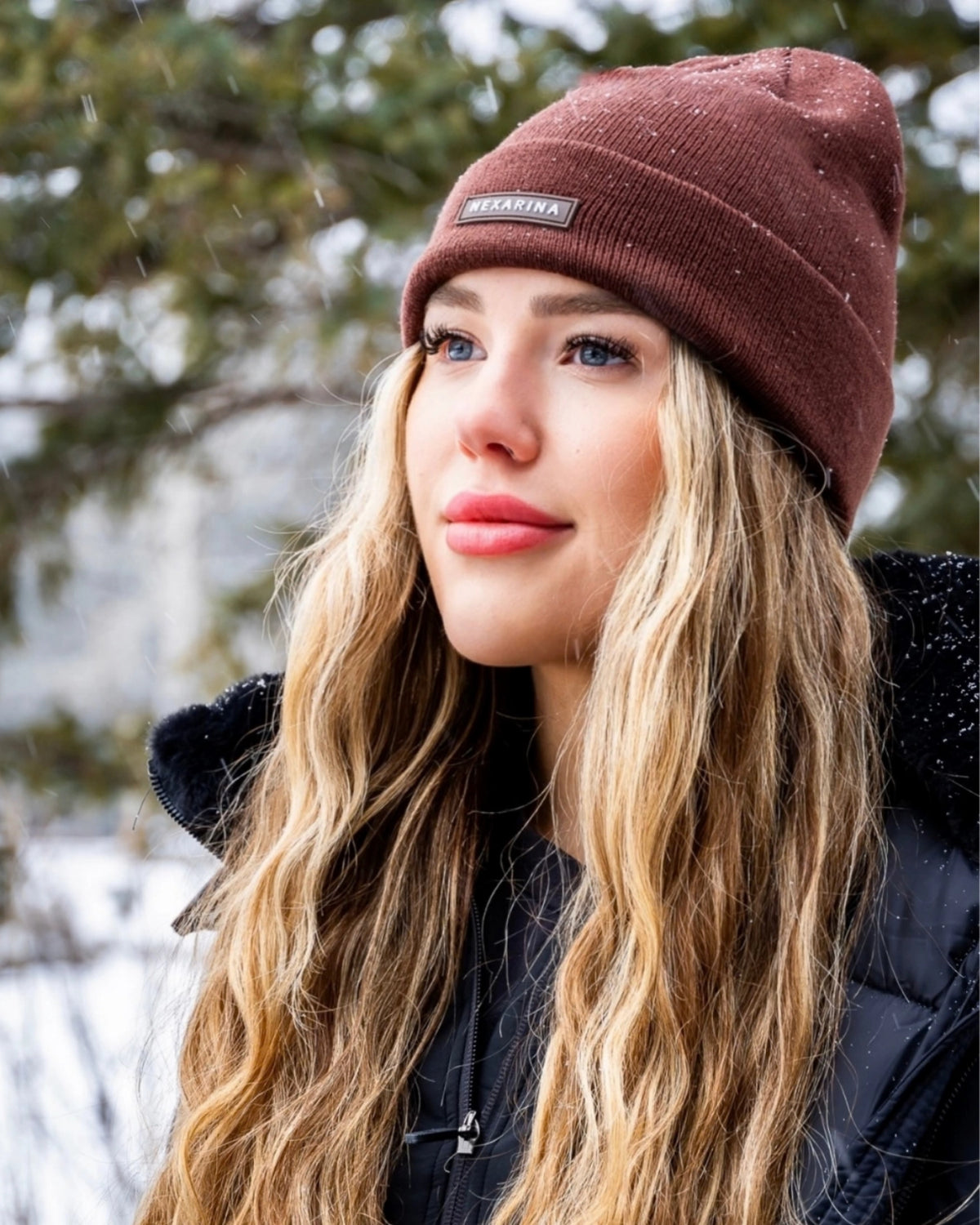 Woman wearing the Nexarina Coco brown knit beanie outdoors in winter