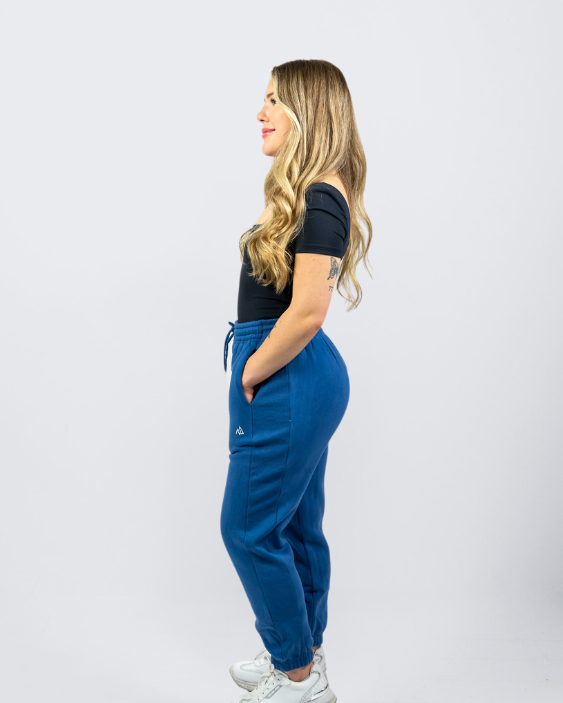 Woman wearing Nexarina Dusty Blue Sweatpants smiling and looking to the side.