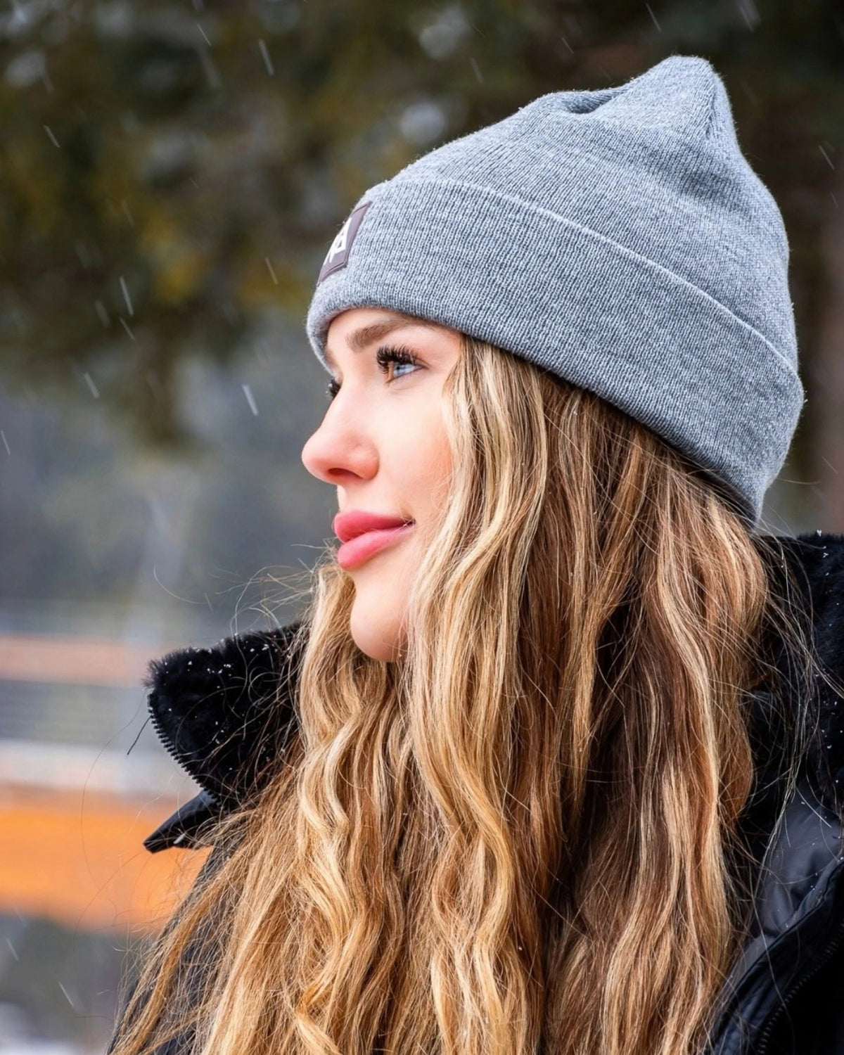Side profile of woman wearing grey Nexarina beanie