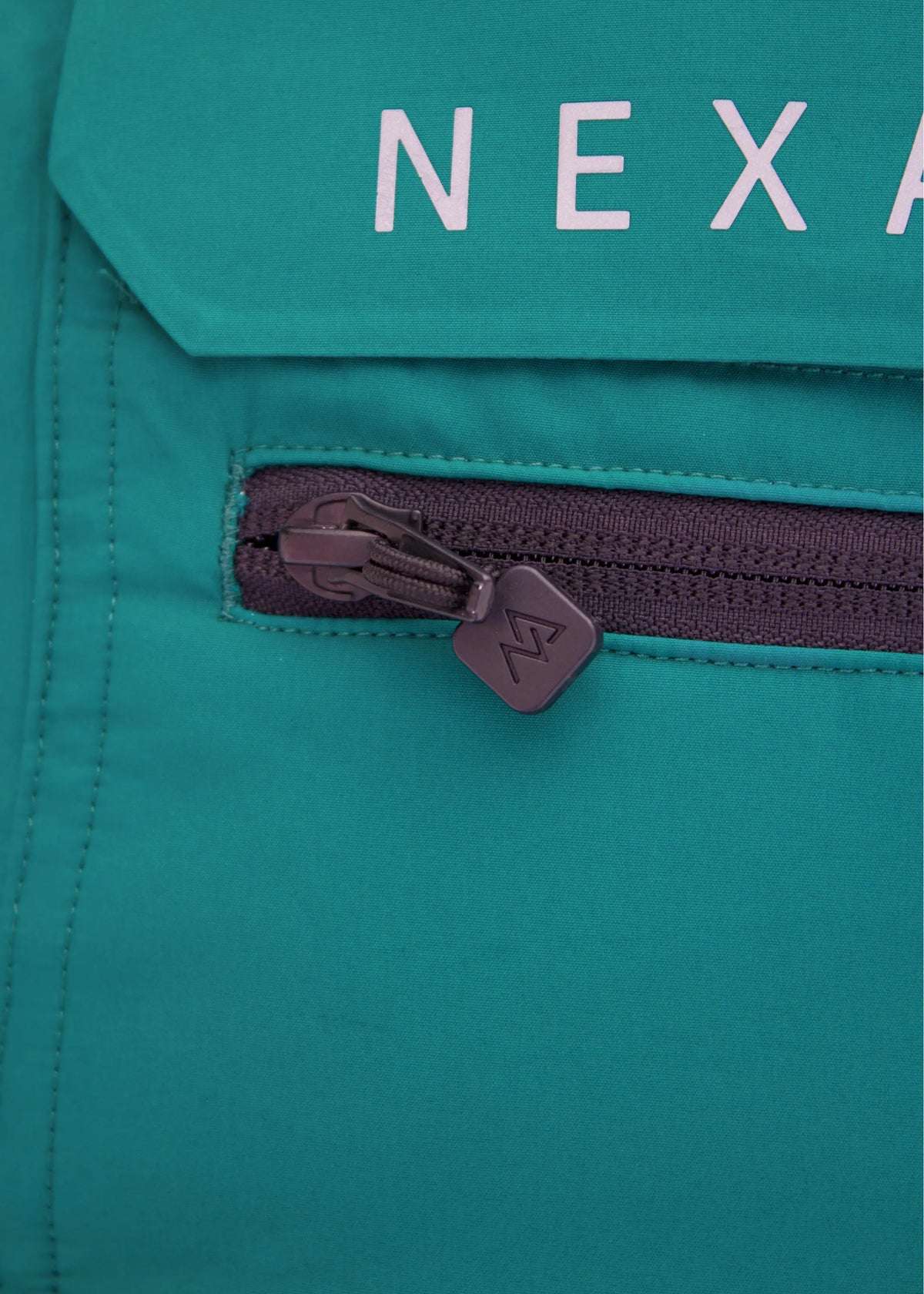 Close-up of Nexarina Everette Emerald Green bib chest pocket and Nexarina branding.
