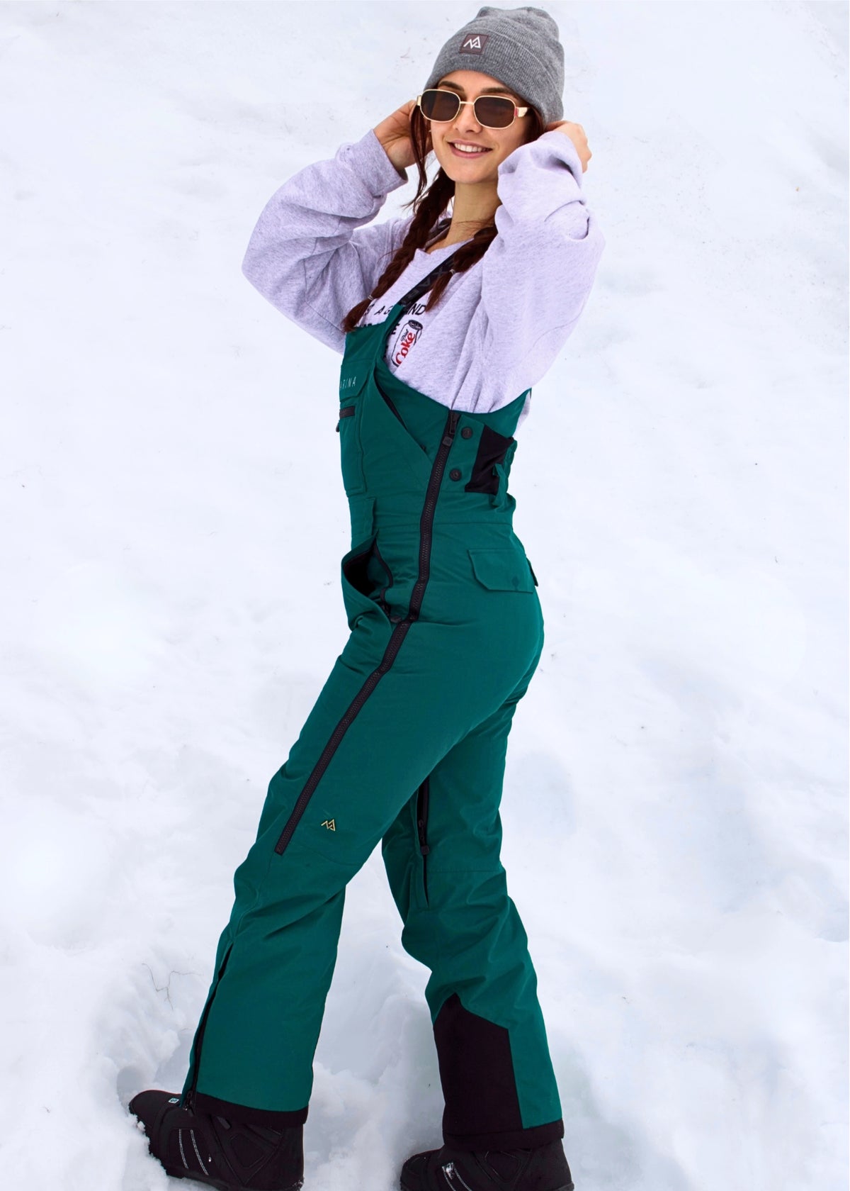 Side view of Nexarina Everette Emerald Green women's snow bibs showing the fit and silhouette.