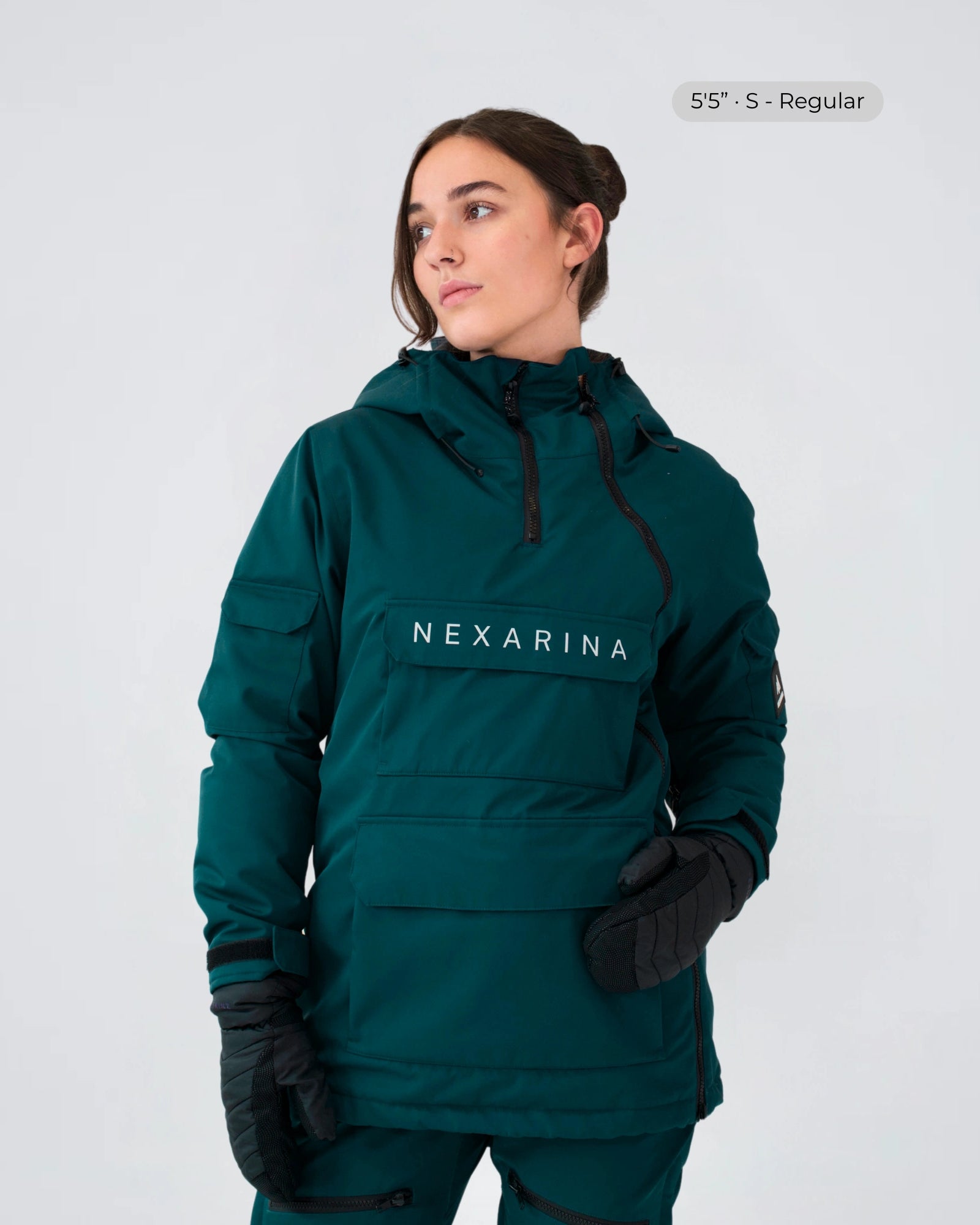 Model wearing Nexarina Indy snow jacket in emerald green, studio front view