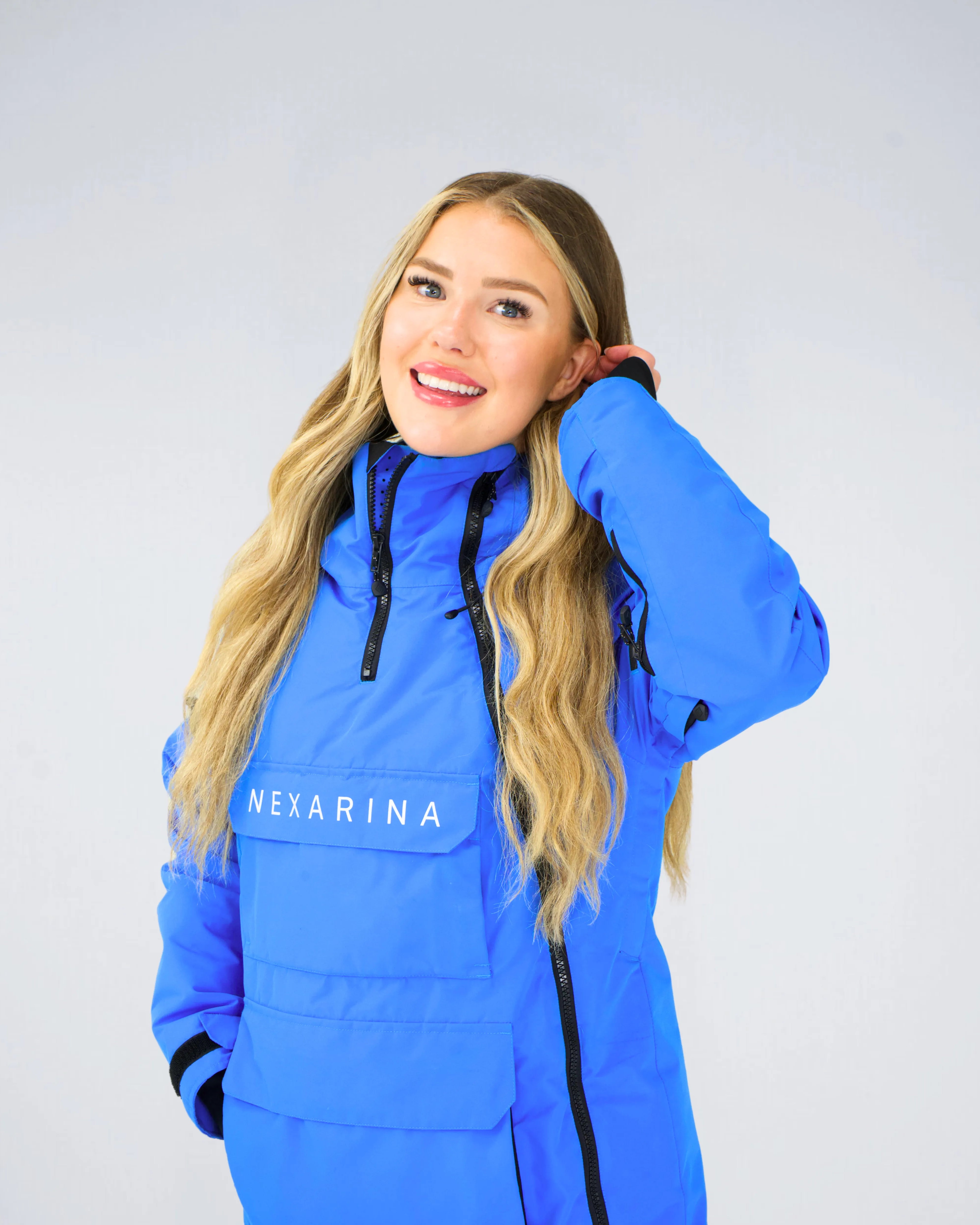 Woman wearing Nexarina Indy Jacket in Arctic Blue technical snow outerwear.