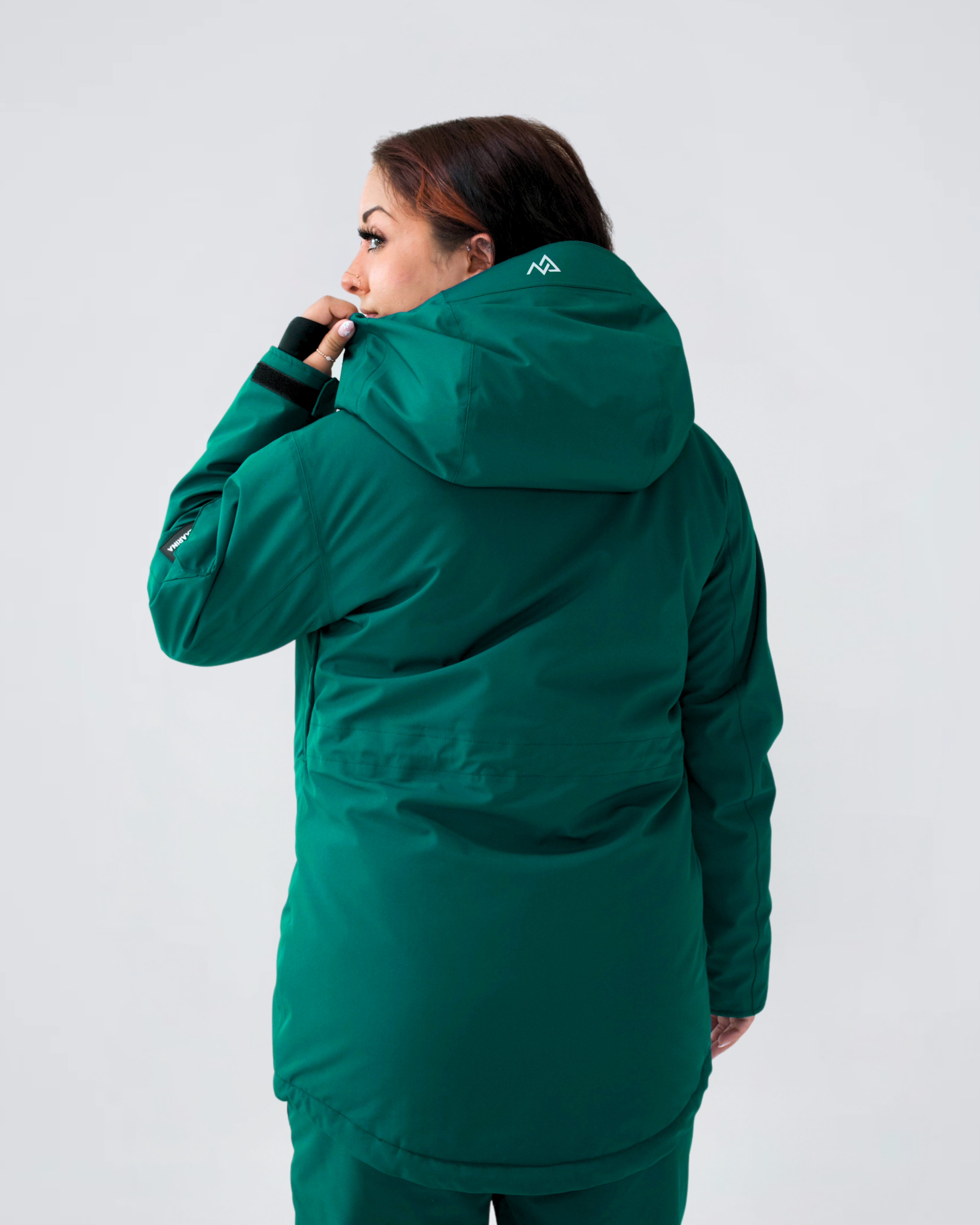 Woman showing back of Nexarina Indy Jacket in Emerald Green.