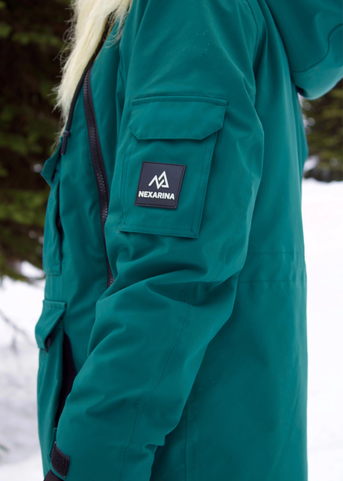 Close-up of Nexarina Indy Emerald Green ski jacket featuring the sleeve pocket and waterproof zipper.