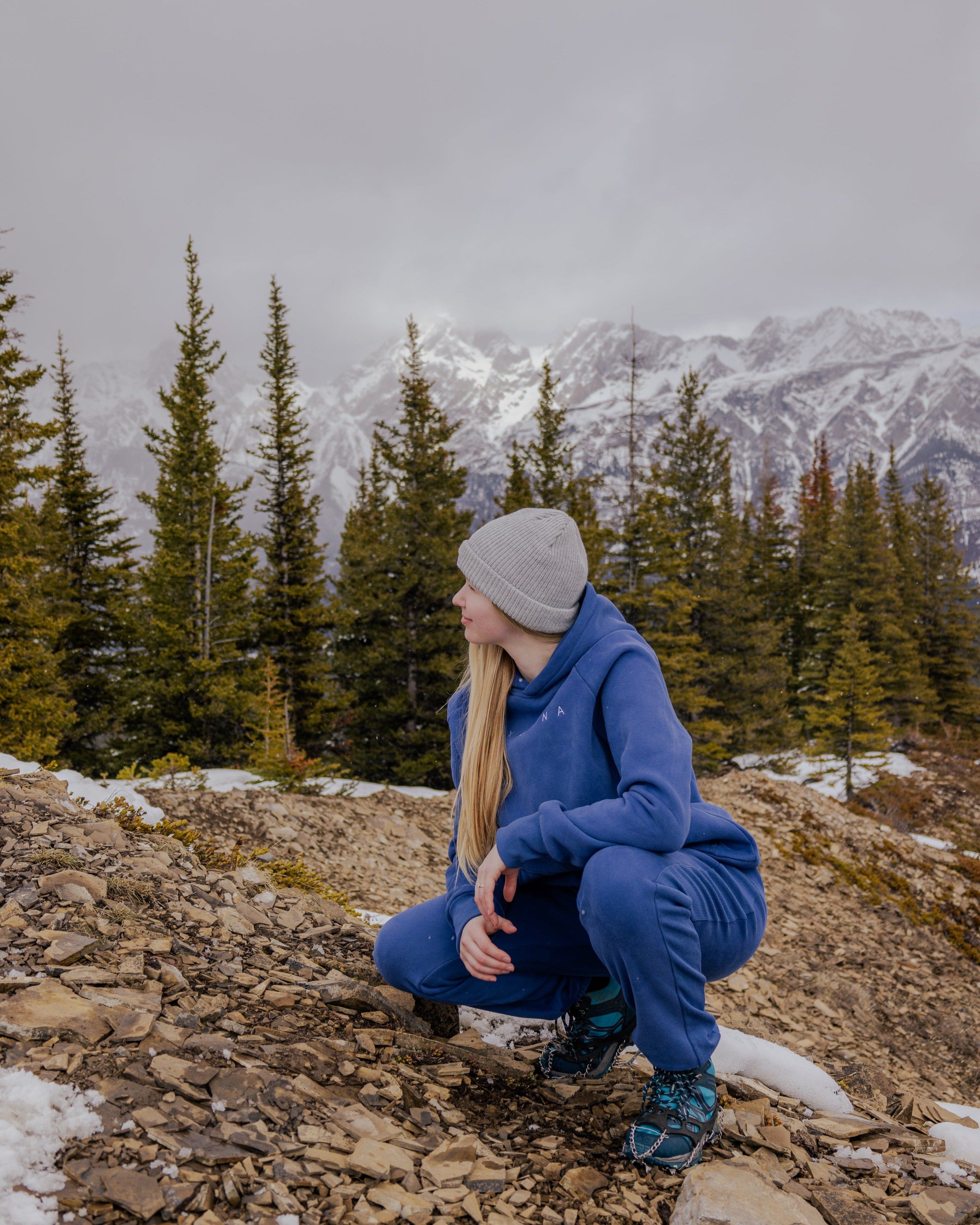 Woman wearing Nexarina Dusty Blue Hoodie in a mountain setting.