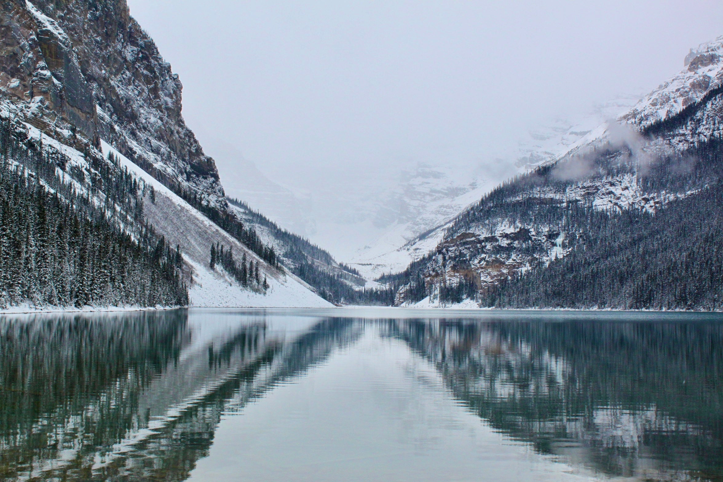 Frozen lake with snow-covered mountains and trees