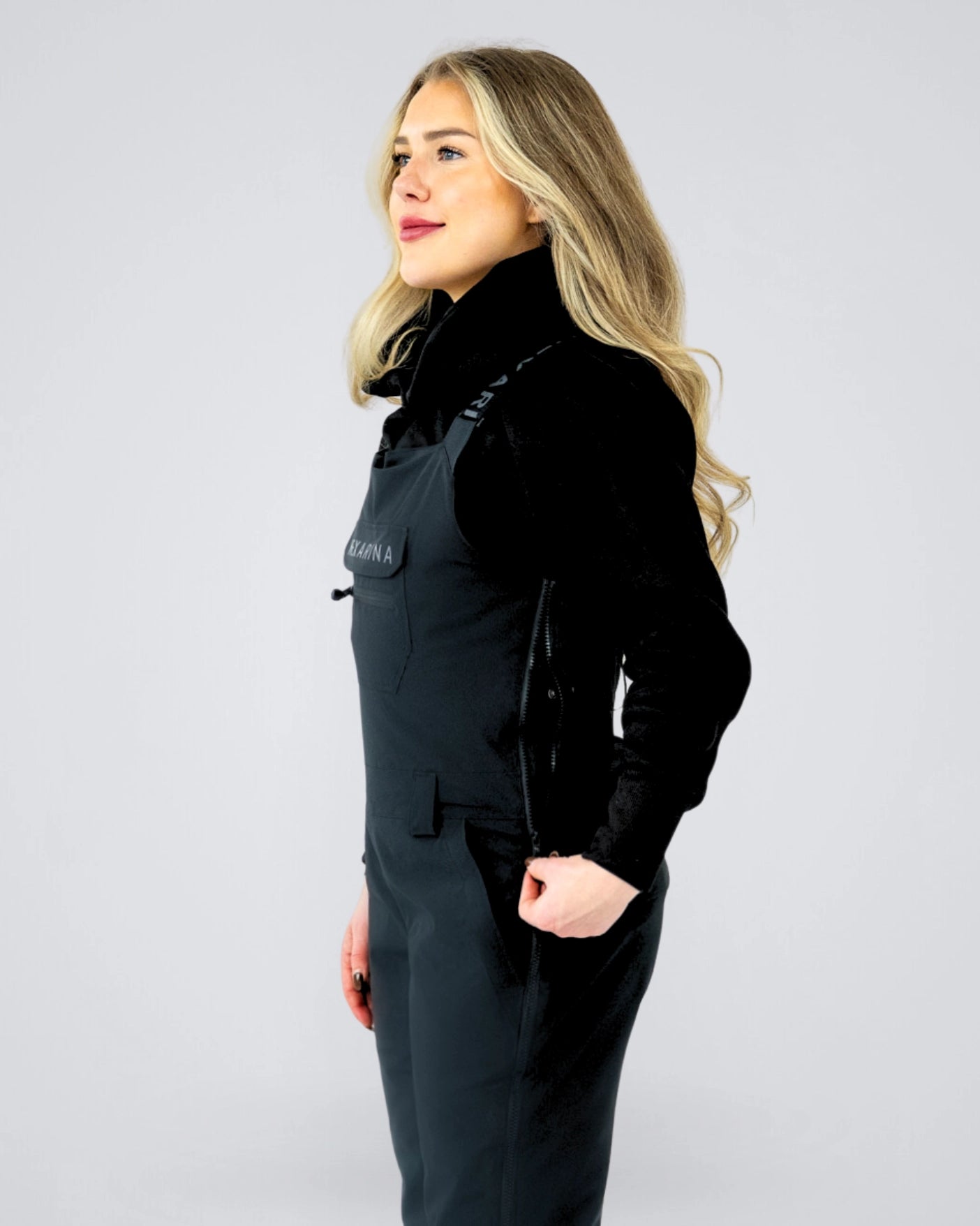 Side profile of Nexarina Everette women’s black bib snow pants with streamlined bib design and women’s fit.