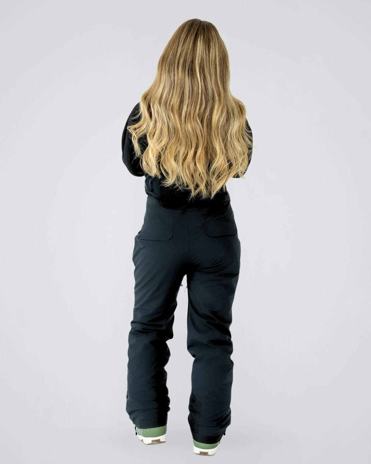 Back view of Nexarina Everette women’s black bib snow pants showing contoured seat and rear pocket design.