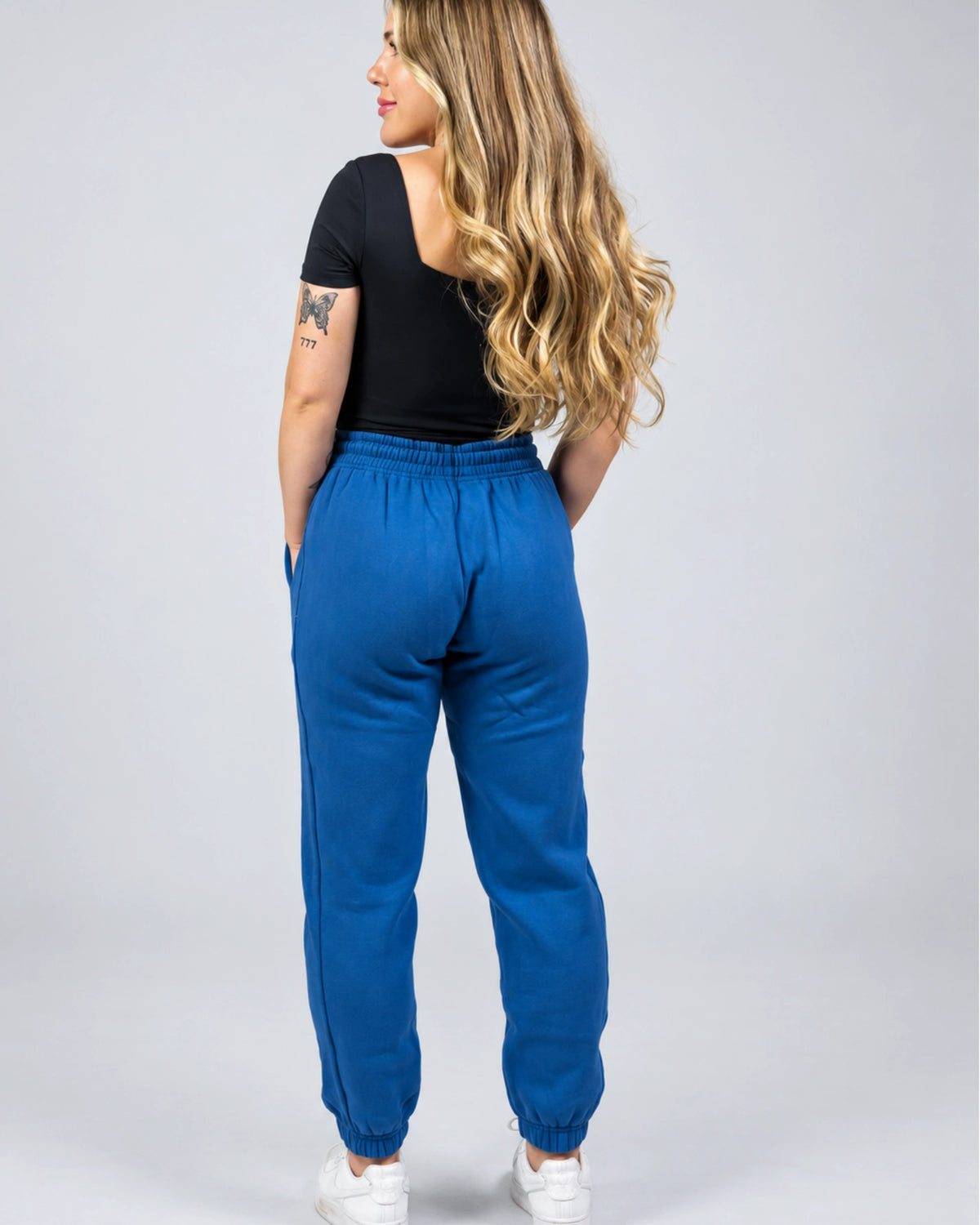 Back view of the women's Willow Sweatpants in Dusty Blue showing the relaxed fit, waistband and cuffed ankles.
