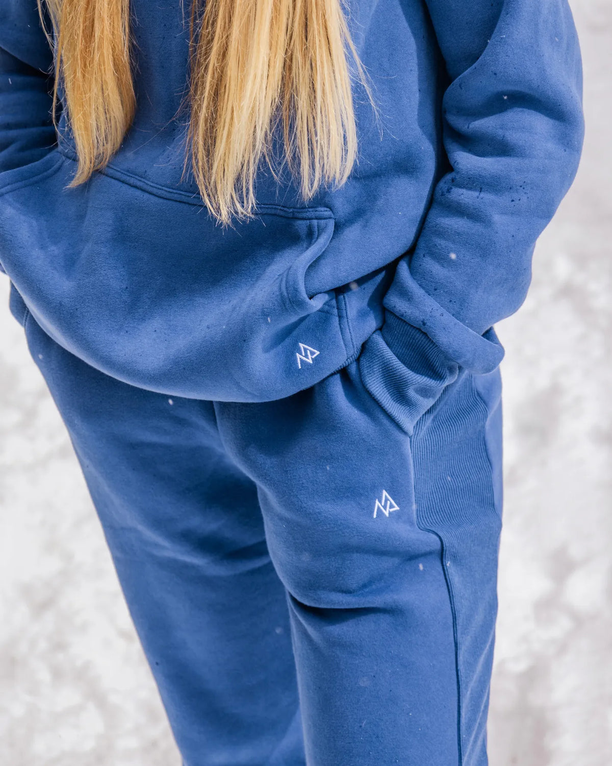 Close-up of the Willow women's sweatpants and matching hoodie in Dusty Blue showing the side rib panel, pocket and Nexarina logo.