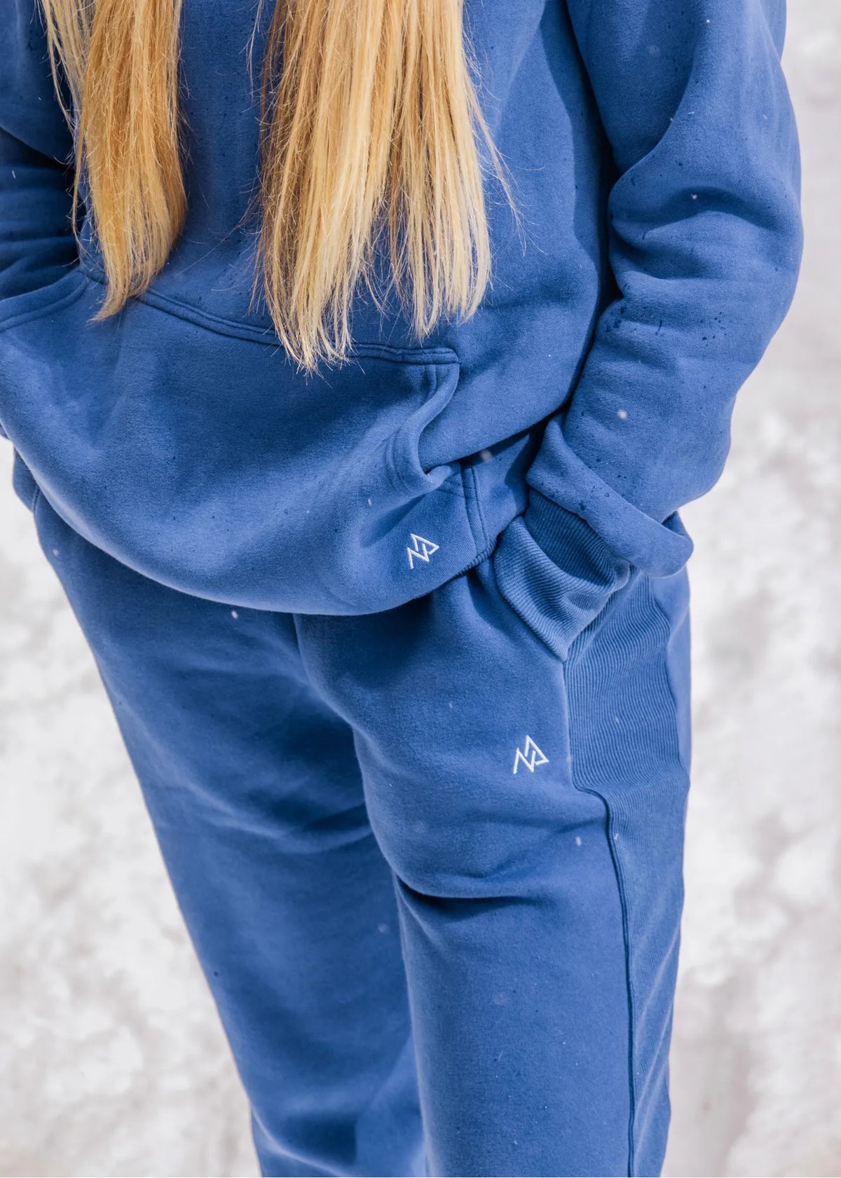 Close-up of the Willow women's sweatpants and matching hoodie in Dusty Blue showing the side rib panel, pocket and Nexarina logo.