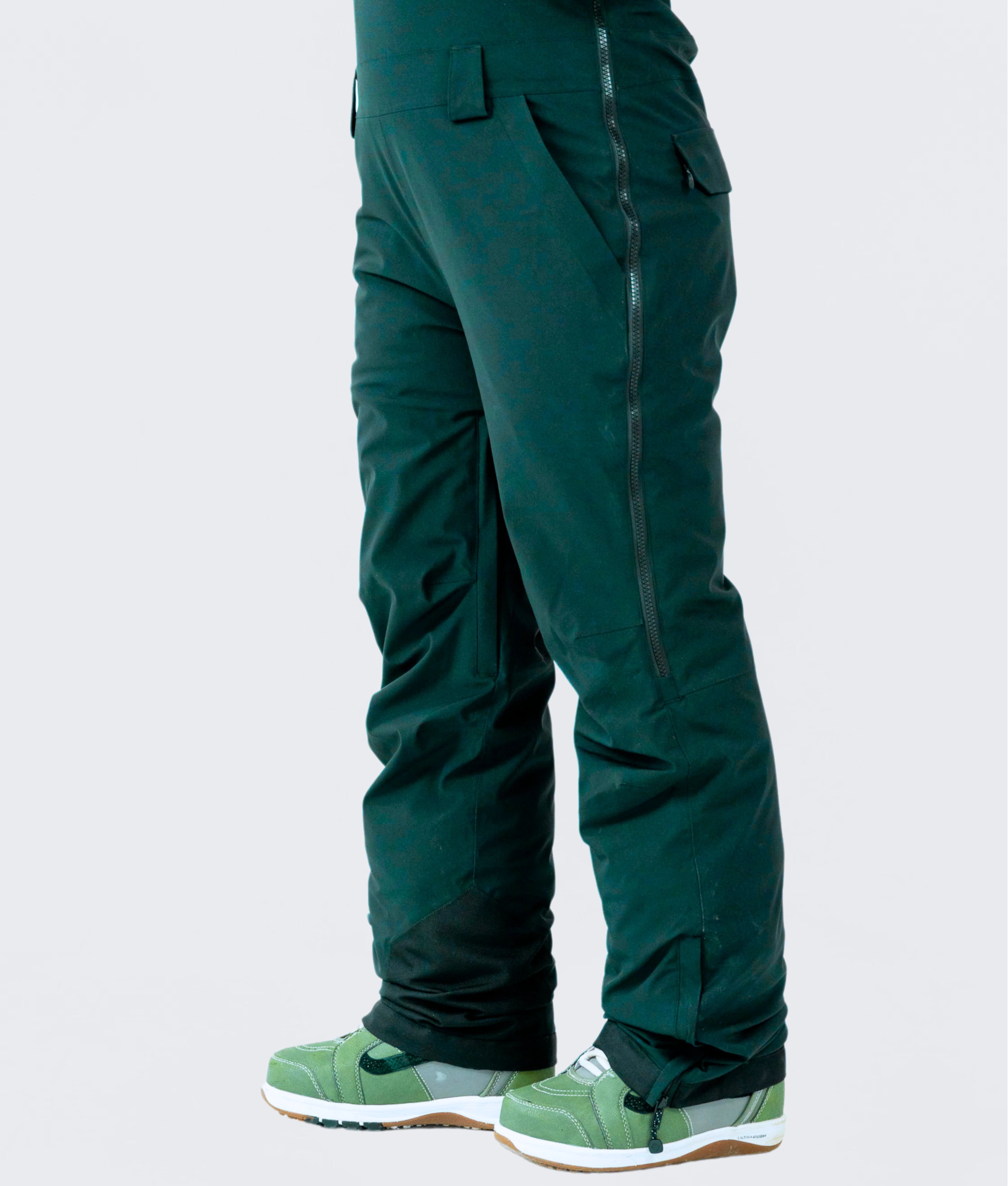 Side view of women's emerald green snow bib pants, designed for snowboarding and mountain adventures.
