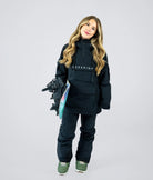 Woman wearing Nexarina Indy black snow jacket holding snowboard, relaxed stance