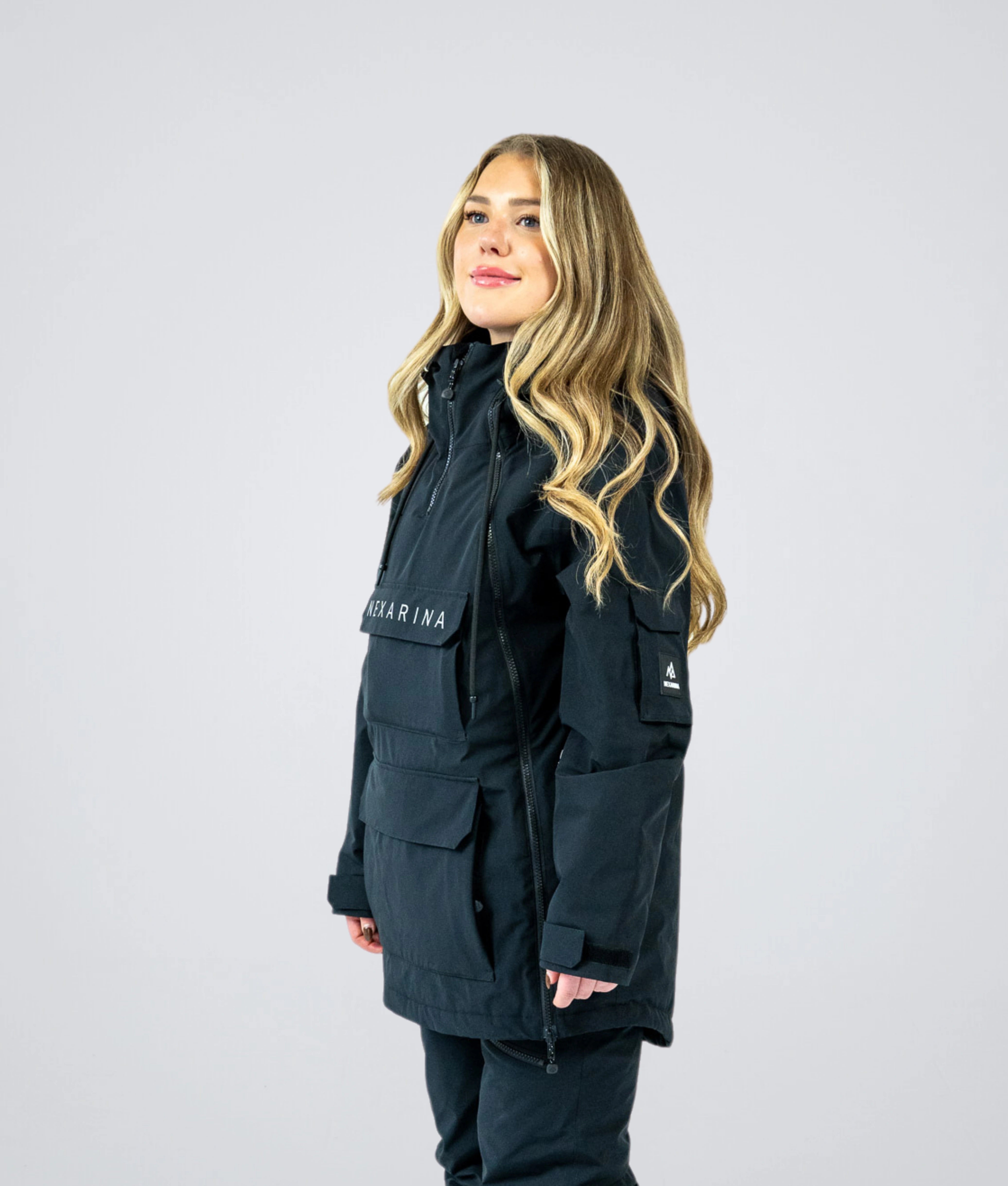 Woman wearing Nexarina Indy Snow Jacket in Classic Black, angled side view.