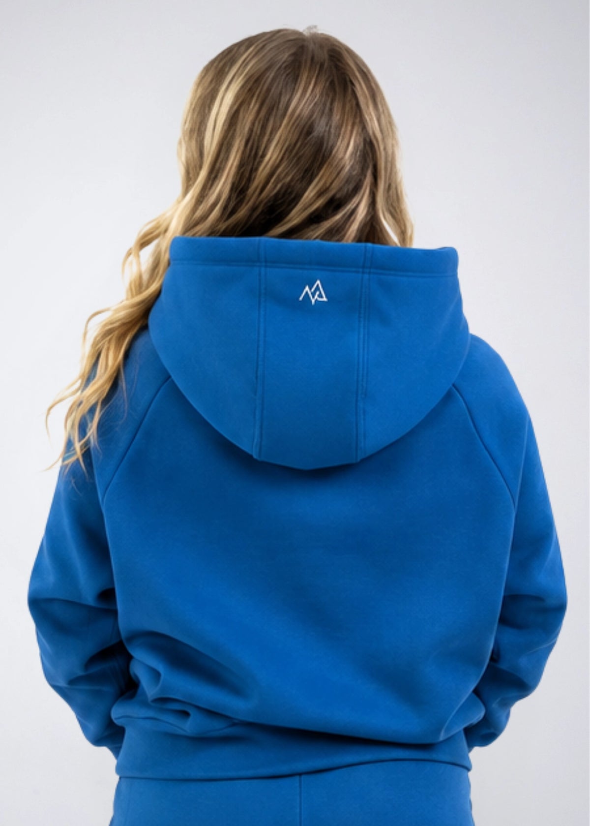 Back view of the Nexarina Everly Hoodie in Dusty Blue showing the hood and back logo