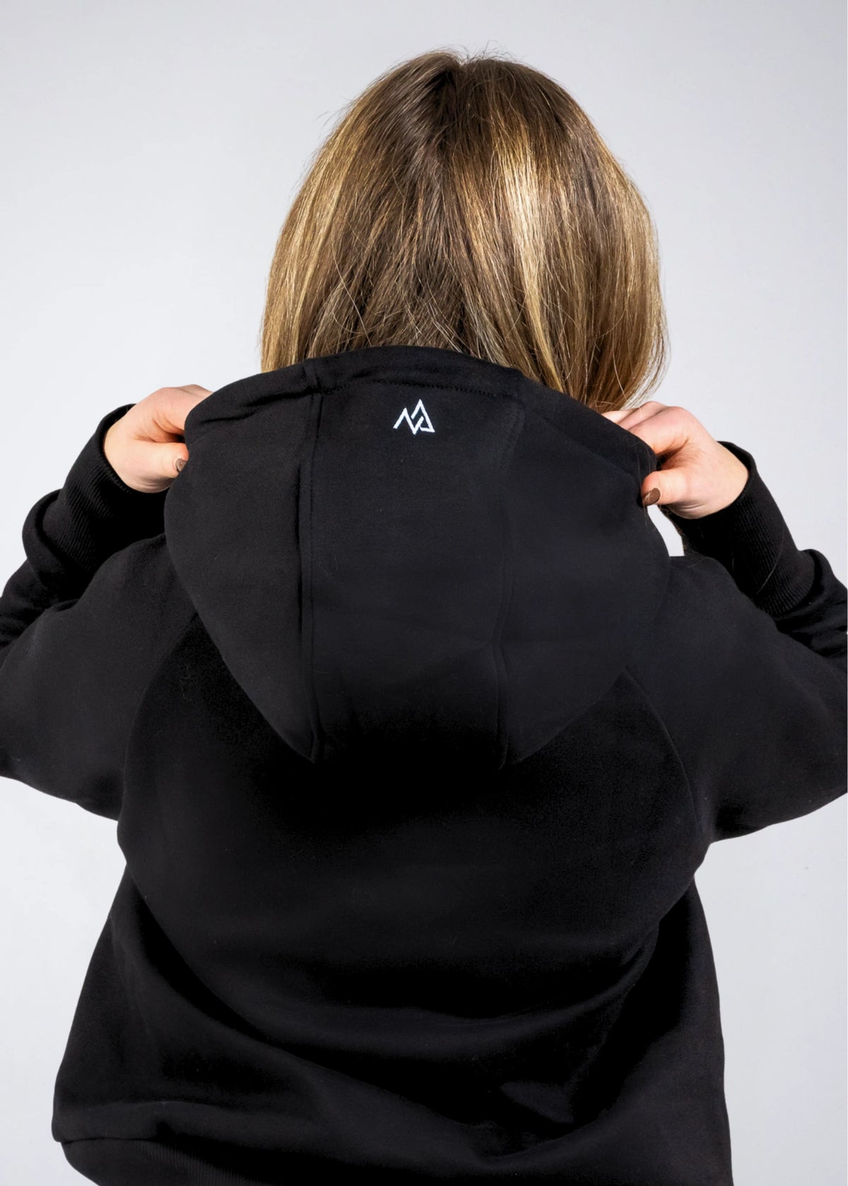 Close-up of the Everly Hoodie hood in Midnight Black showing the Nexarina logo detail.