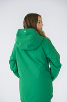 Back view of the green Nexarina Indy snow jacket worn by a model, showing the hood.