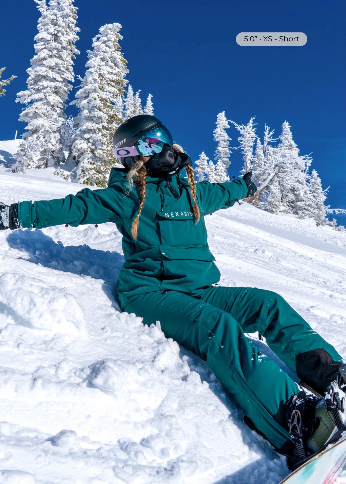 Nexarina Avani women's emerald green snowboard pants sitting in powder 