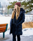 Woman wearing the Nexarina Coco brown beanie with a black winter jacket