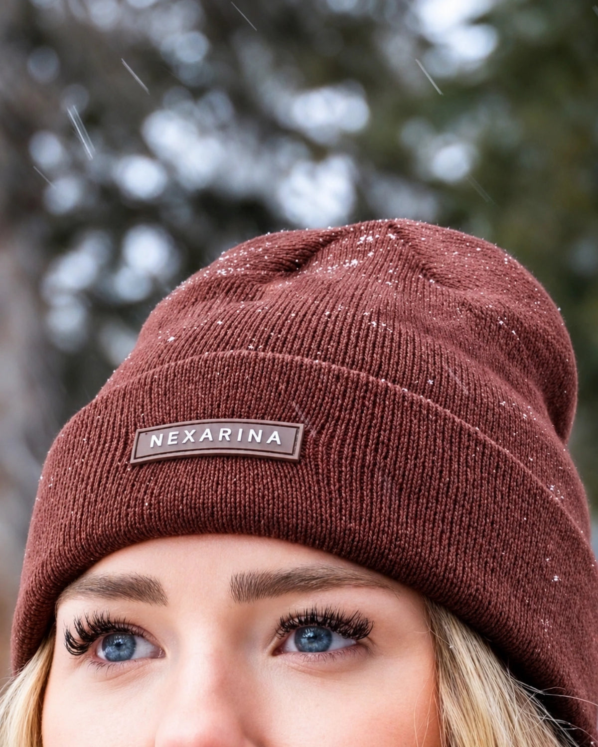 Close-up detail of the Nexarina logo on the Coco brown beanie