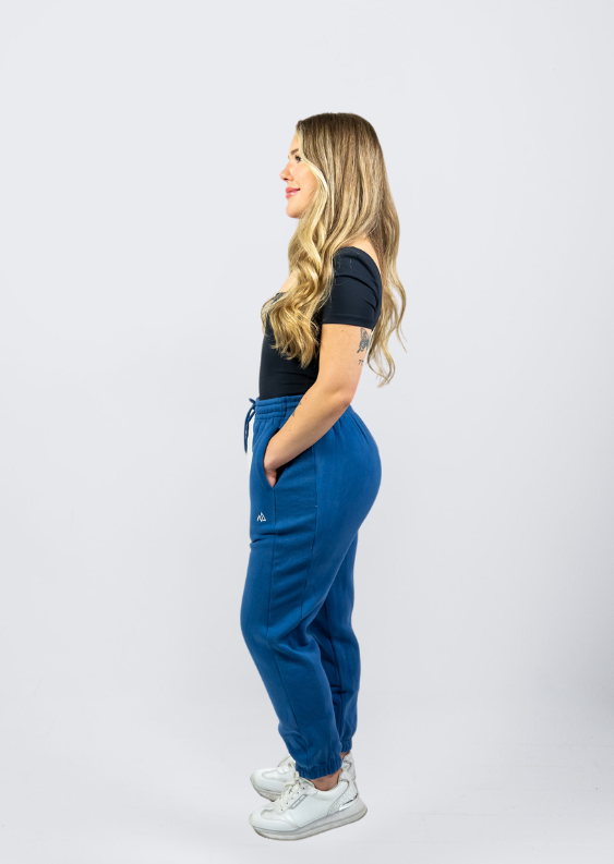 Woman wearing Nexarina Dusty Blue Sweatpants smiling and looking to the side.