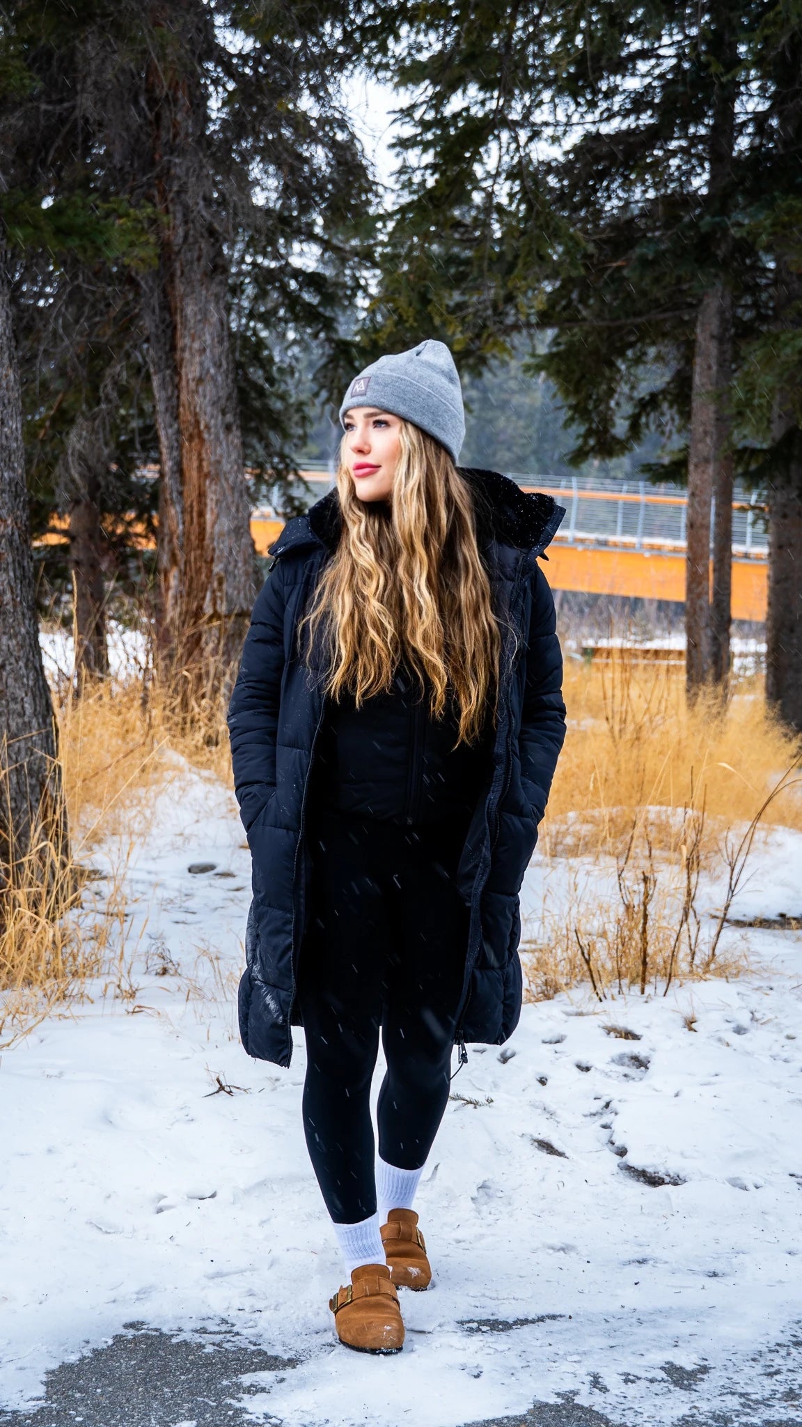 Women in grey Emery beanie wearing a mountain style outfit. 