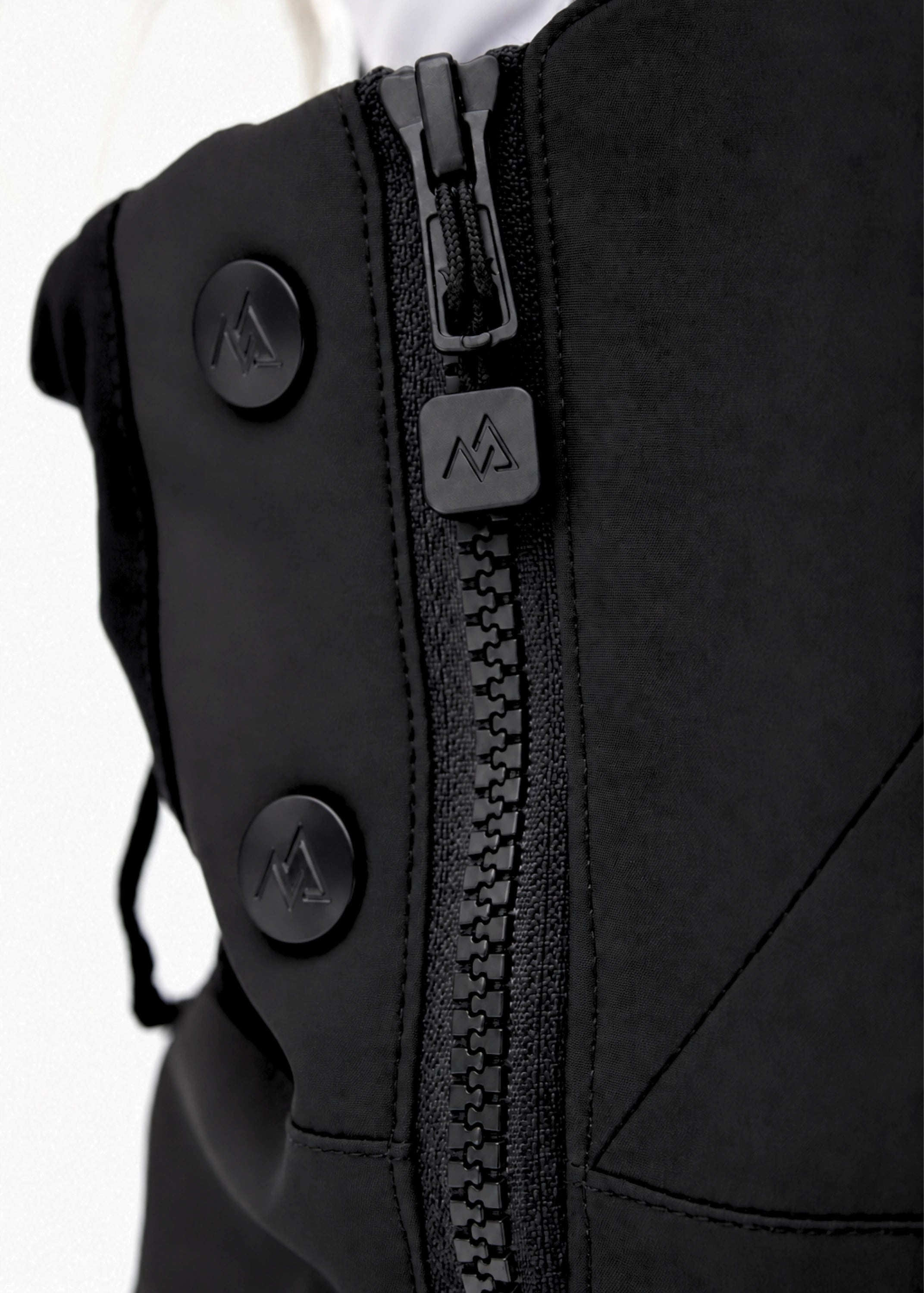 Close-up of Nexarina Everette Classic Black snow bibs showing the side zipper, branded puller and snap buttons.