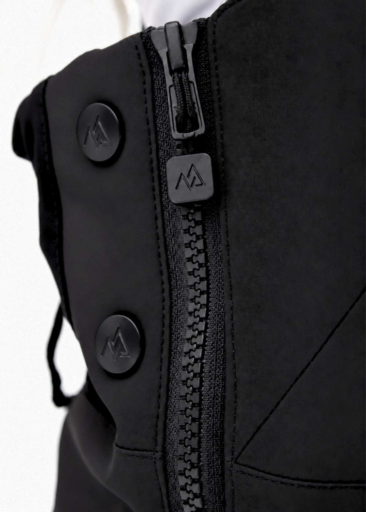Close-up of Nexarina Everette Classic Black snow bibs showing the side zipper, branded puller and snap buttons.