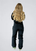 Full-length rear view of Nexarina Everette Classic Black women's snow bibs showing the fit, rear pockets and leg length.