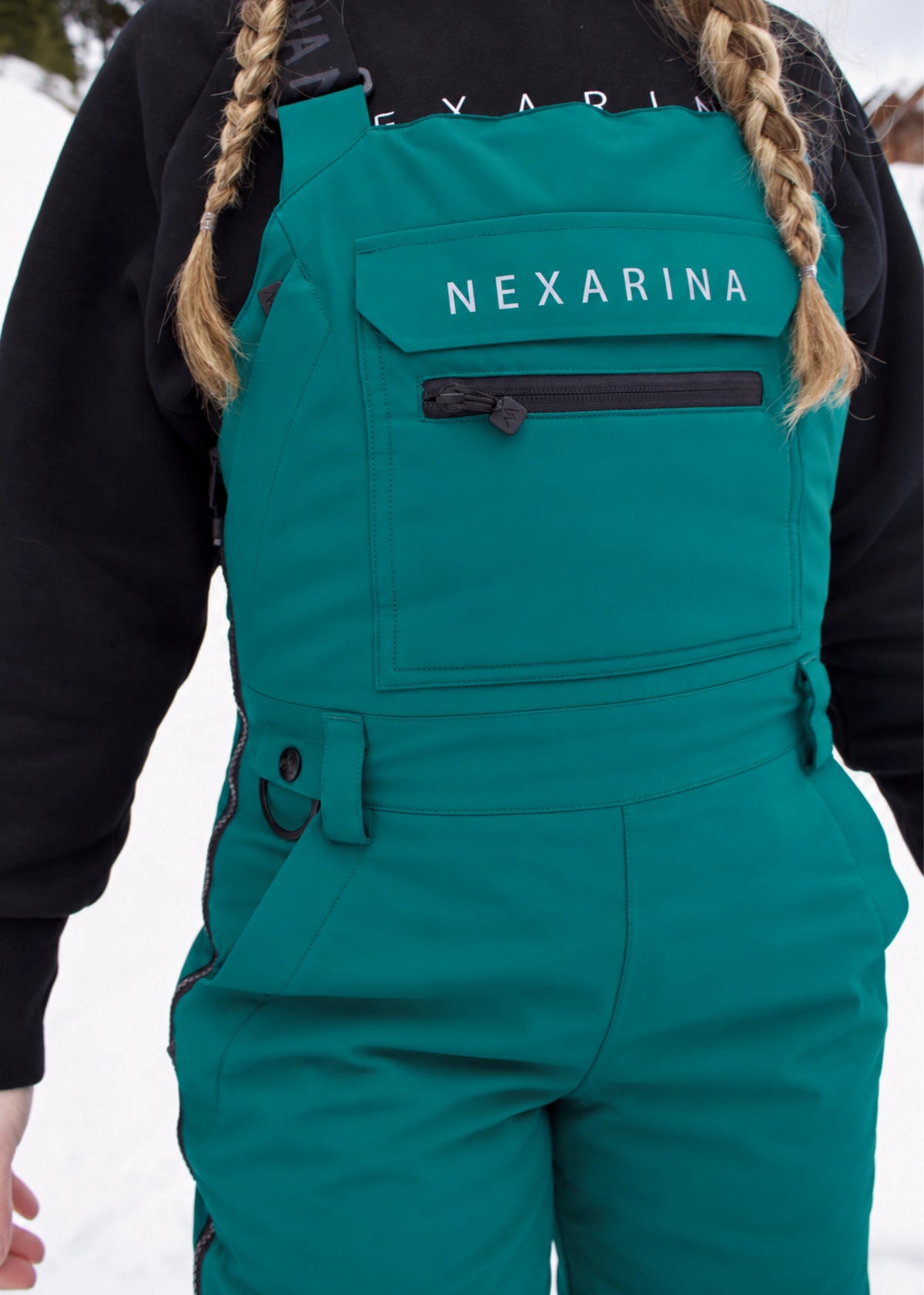 Front close-up of Nexarina Everette Emerald Green snow bibs showing the chest panel and pocket details.