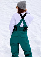 Rear close-up of Nexarina Everette Emerald Green women's snow bibs showing the back fit and strap design.
