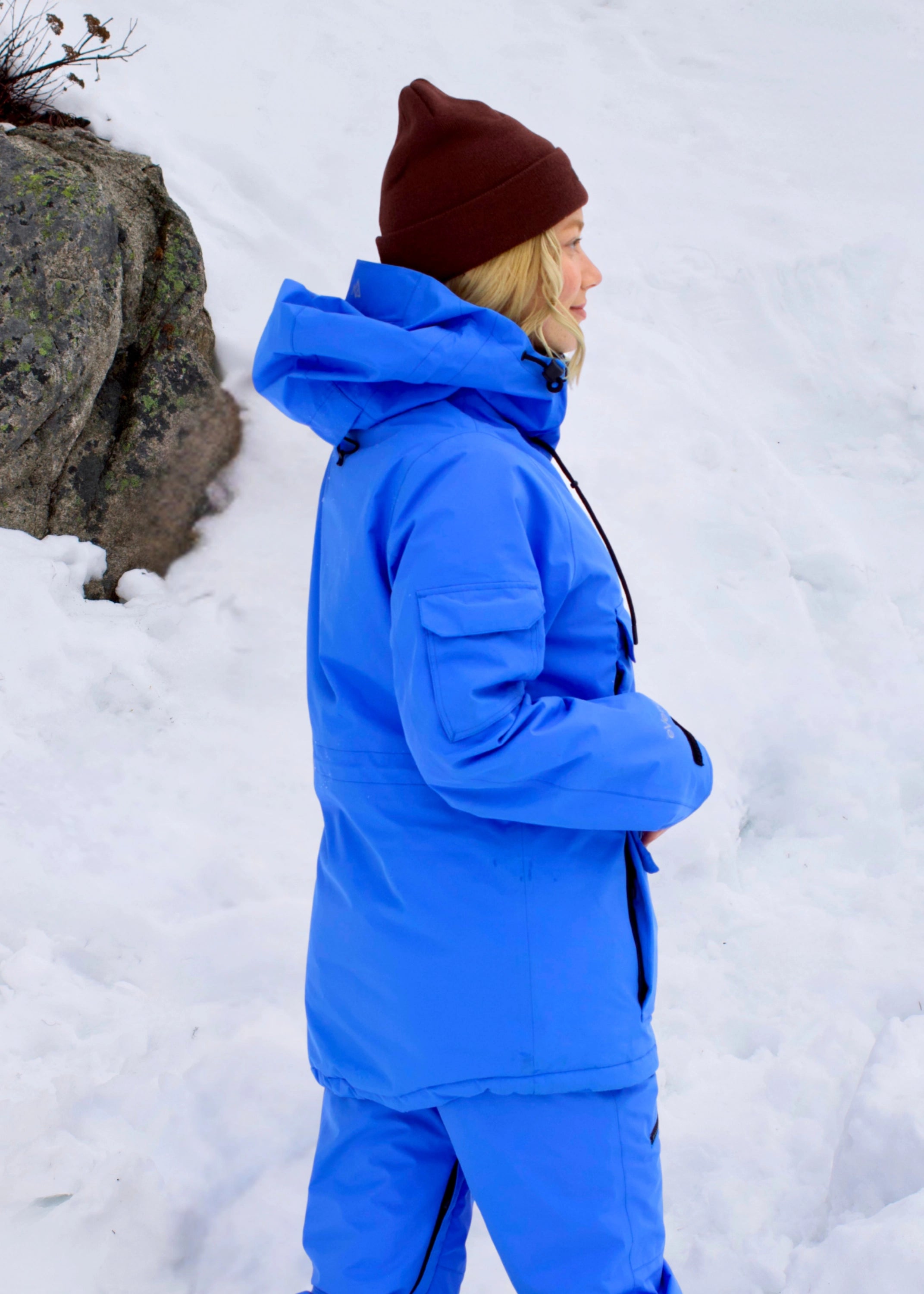 Rear view of Nexarina Indy Arctic Blue women's insulated ski jacket, showing the hood, sleeve pocket and jacket length.