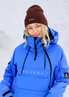 Close-up of woman wearing Nexarina Indy Arctic Blue ski jacket, featuring the high collar, waterproof zippers and chest pocket.
