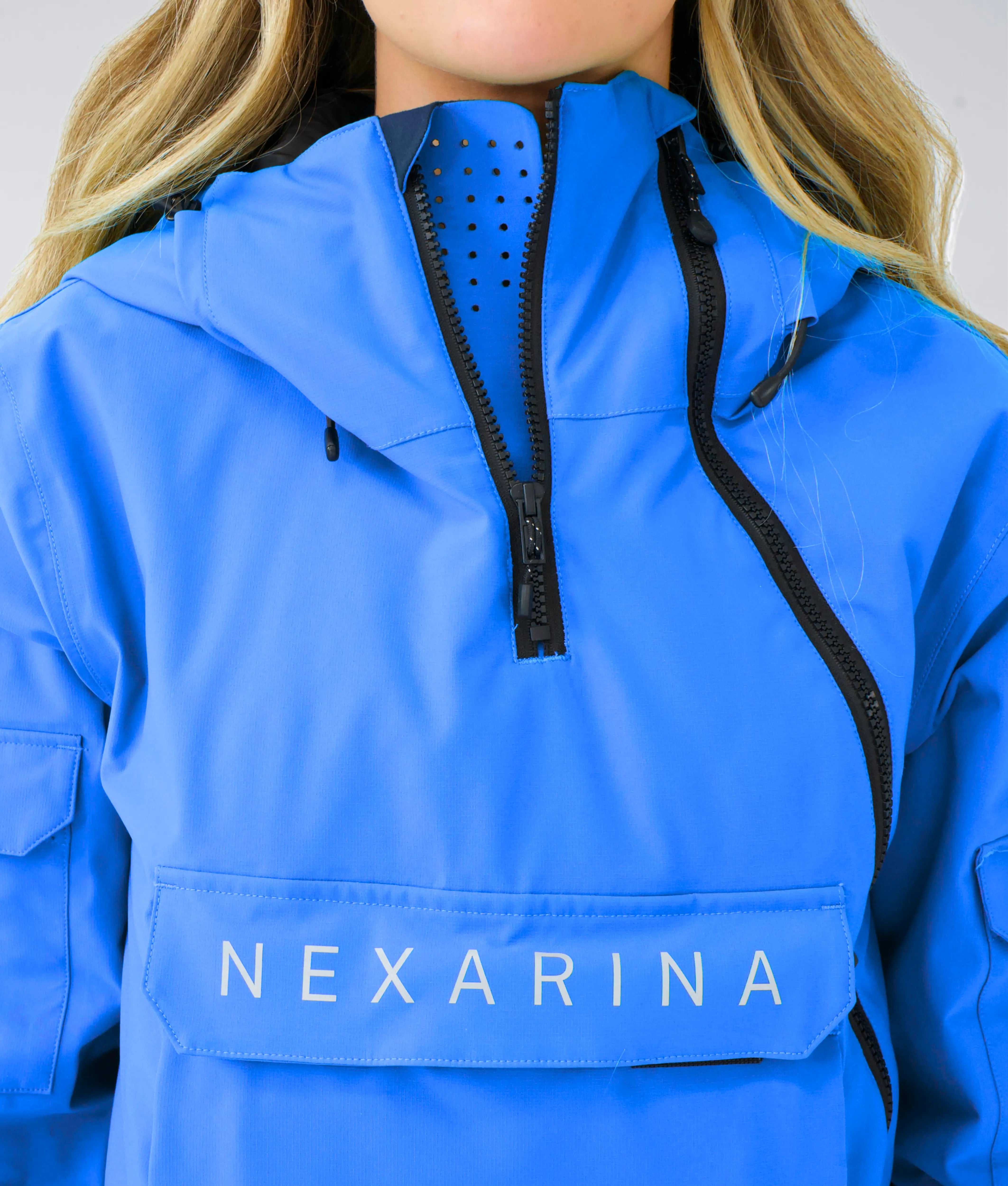 Woman wearing Nexarina Indy Jacket in Arctic Blue showing pocket and zipper details.