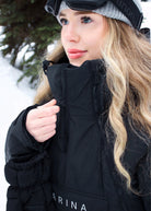 Close-up of woman wearing Nexarina Indy Classic Black ski jacket, showing the high collar and front zipper.