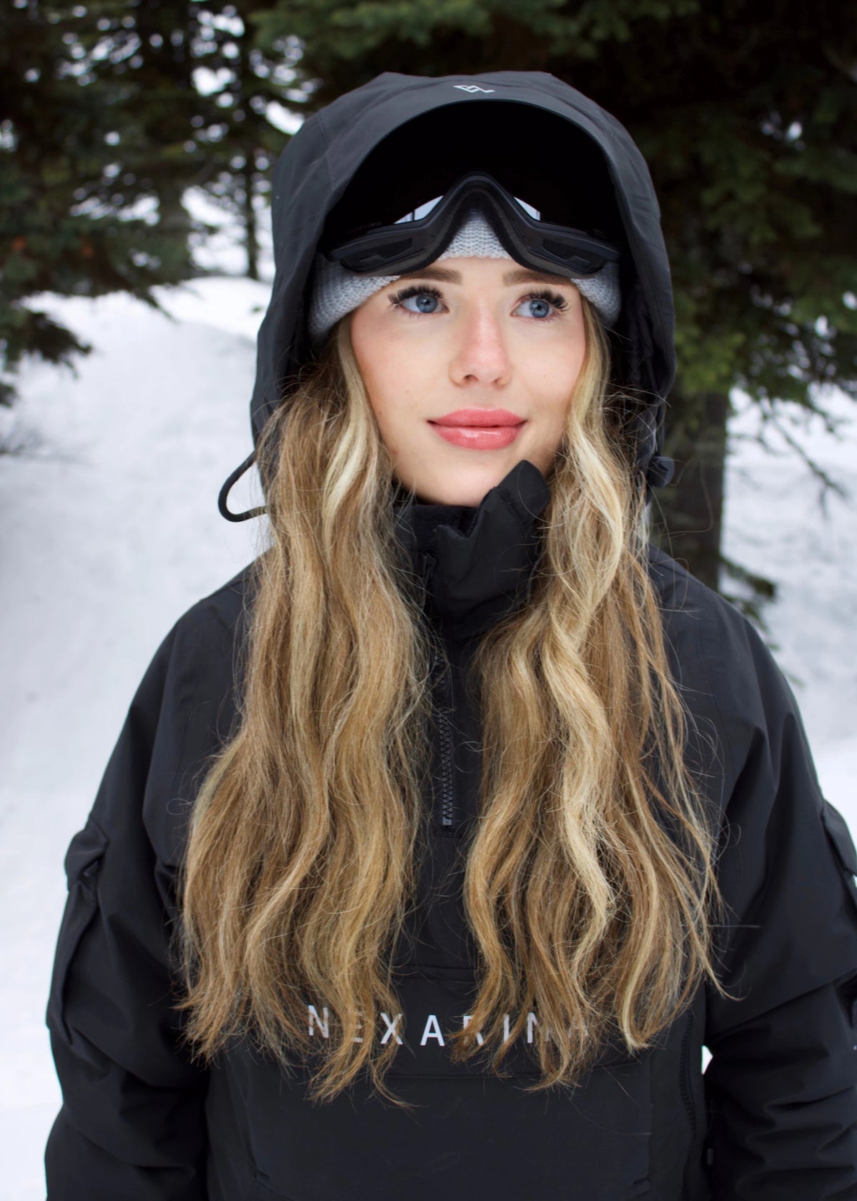 Front view of woman wearing Nexarina Indy Classic Black women's insulated ski jacket with the hood up.