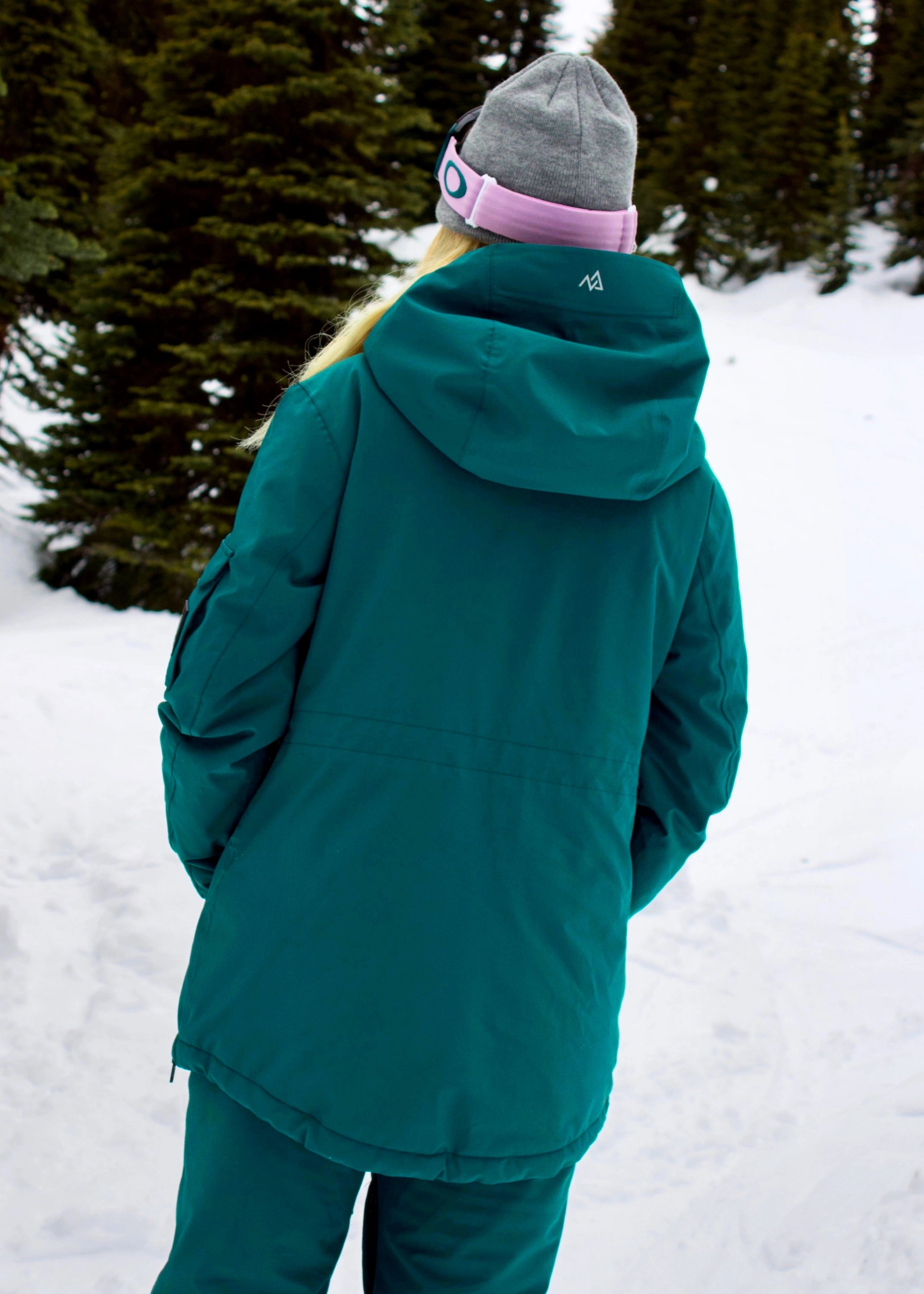 Back view of Nexarina Indy Emerald Green women's ski jacket showing the hood, jacket length and rear fit.