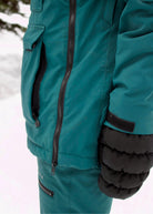 Side view of Nexarina Indy Emerald Green insulated ski jacket showing the sleeve design and fit.