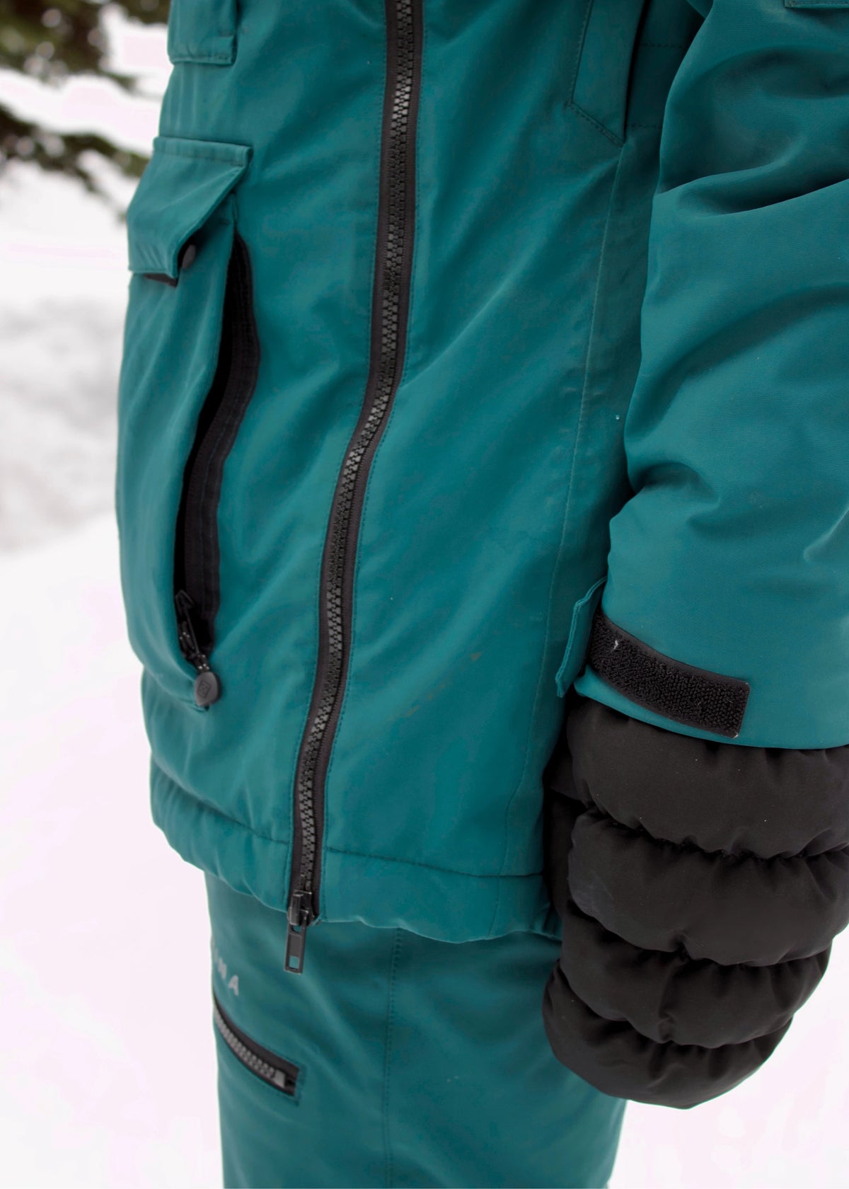 Side view of Nexarina Indy Emerald Green insulated ski jacket showing the sleeve design and fit.
