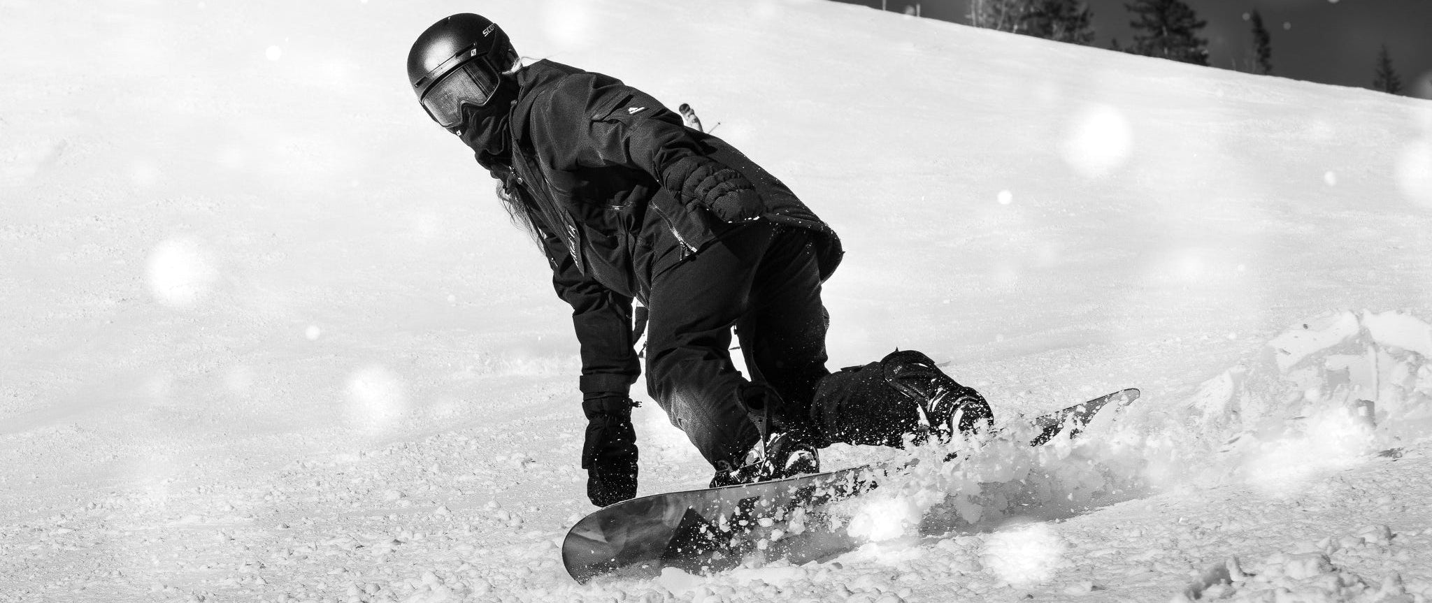 Person snowboarding down a slope with a ski lift in the background
