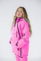 Side profile of a woman in a pink Nexarina snowboard jacket, posed against a white backdrop