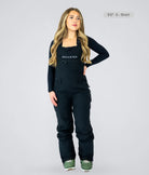 Woman wearing Nexarina Everette women’s black bib snow pants with tailored fit for short women.