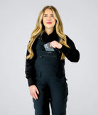Front view of Nexarina Everette women’s bib snow pants in black, showing chest pocket storage and women’s performance fit.
