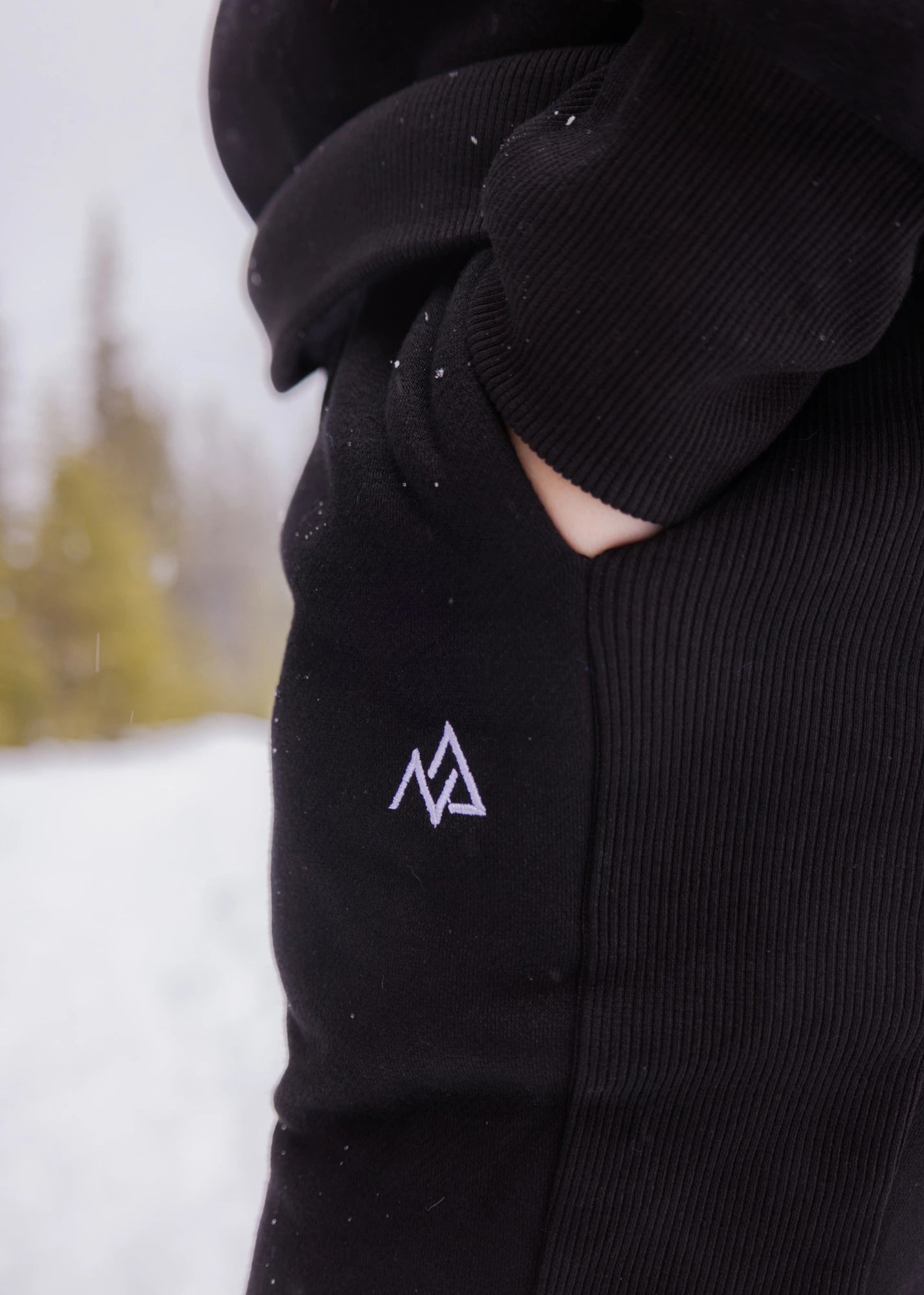 Close-up of the Nexarina logo and ribbed side panel on Midnight Black Willow Sweatpants